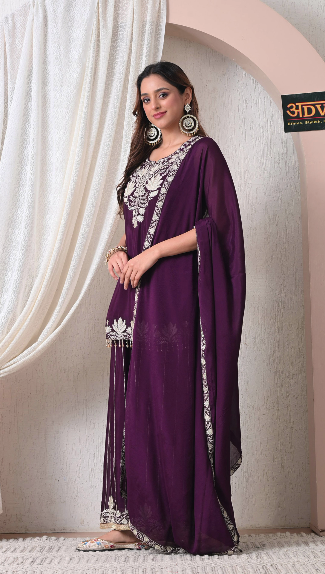 Woman wearing a purple chinon embroidered sharara suit with dupatta